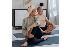 Image An older couple does yoga on some mats.